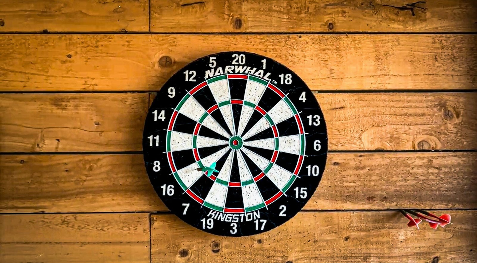 Image of a dartboard against a wooden wall