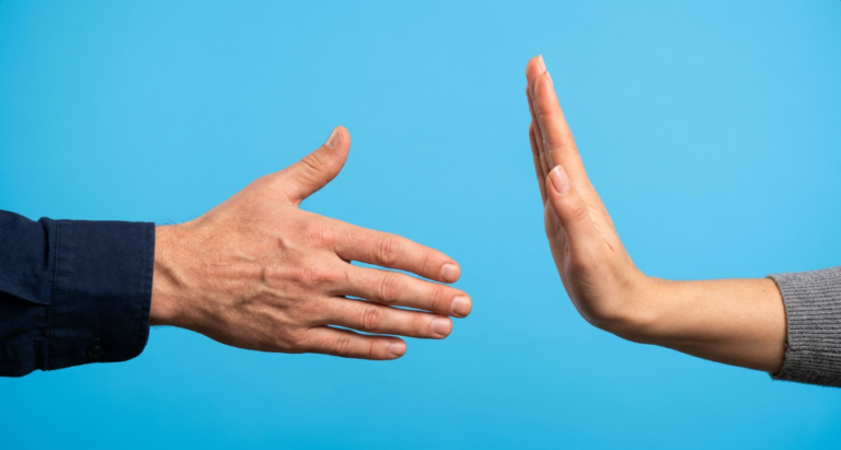 One hand ready for handshake and another hand raised with palm up to pause the handshake