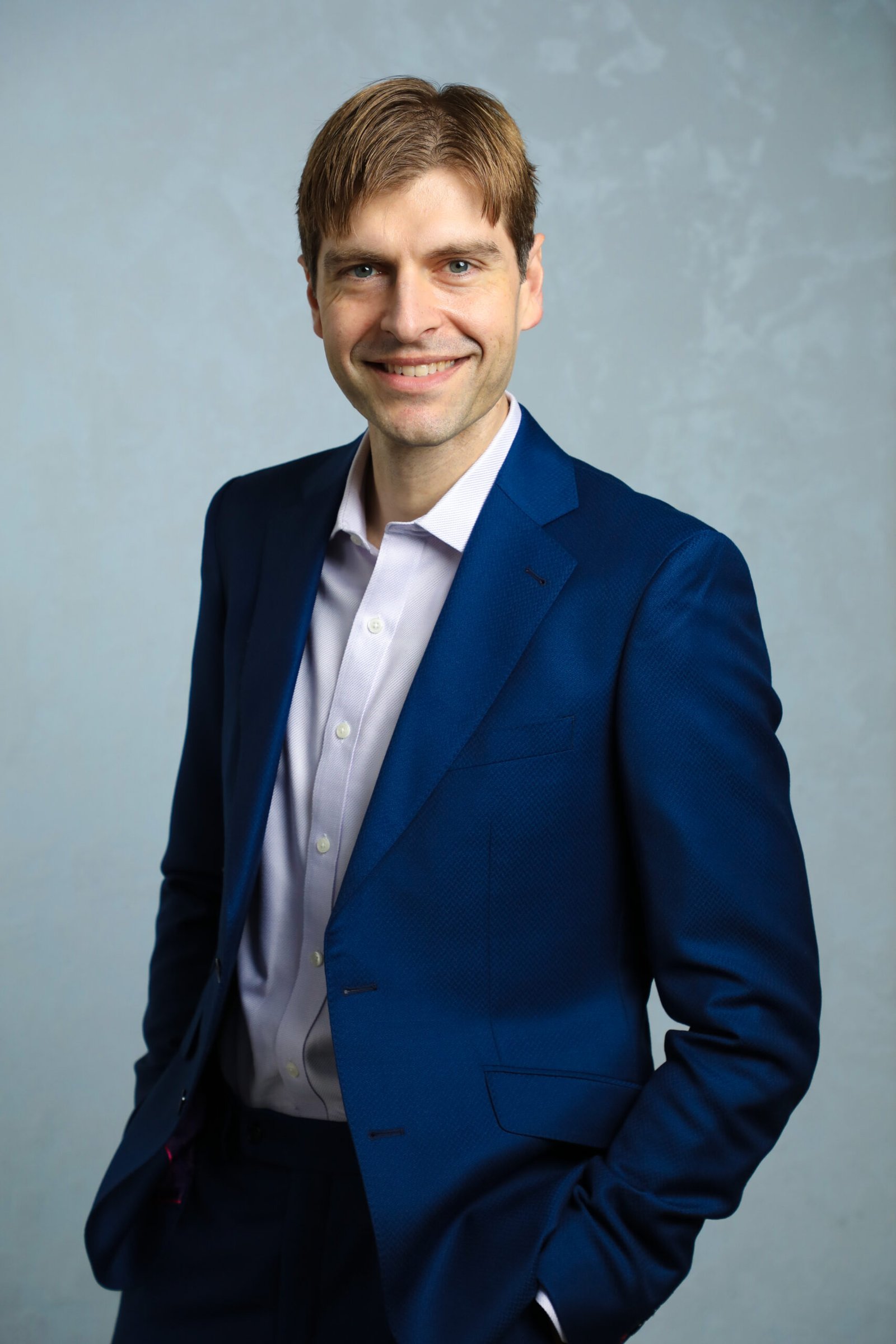 Picture of founder, Vuk Talijan, in suit with hands in pockets and smiling. 