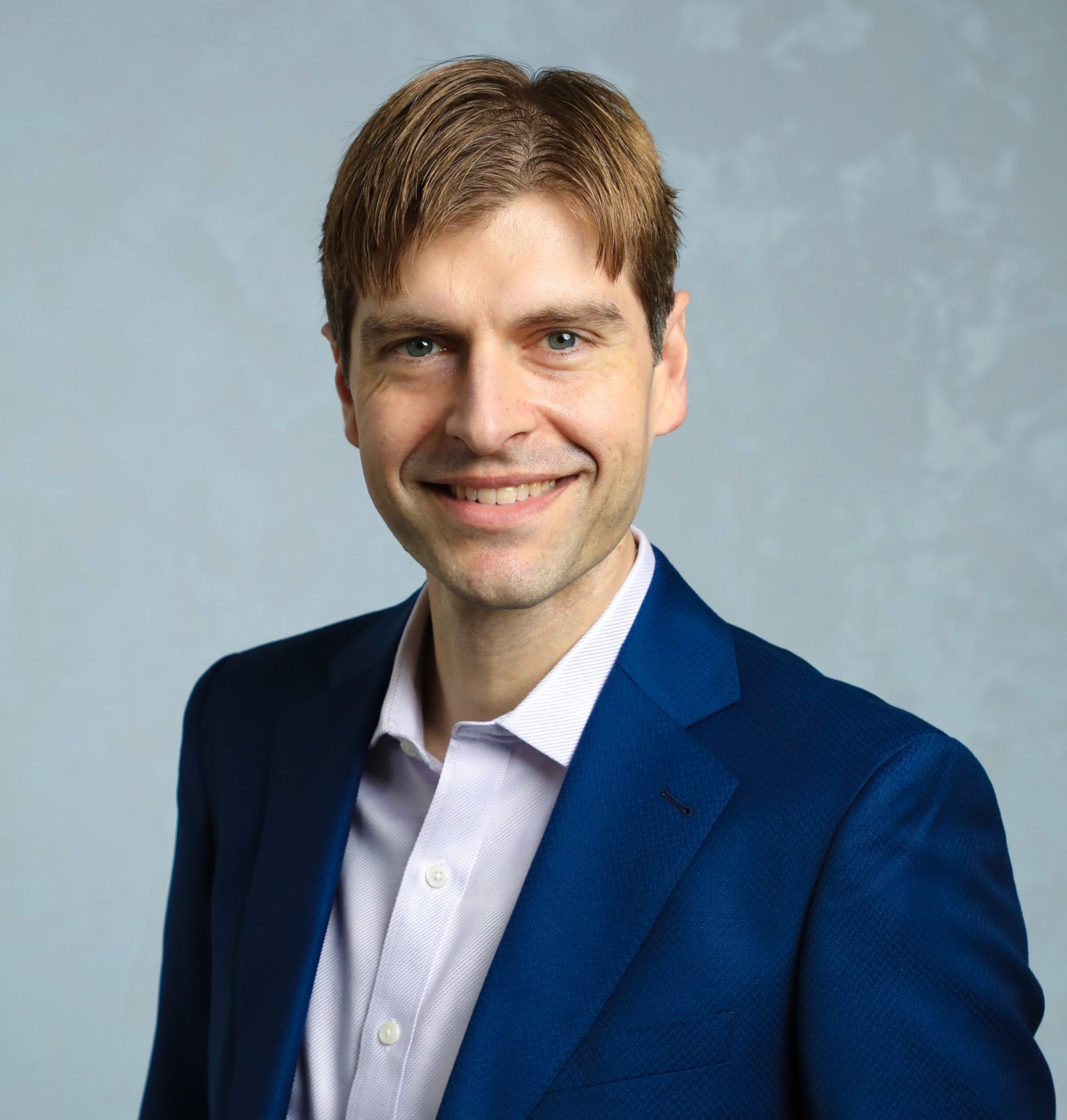 Picture of founder, Vuk Talijan, in suit with hands in pockets and smiling.